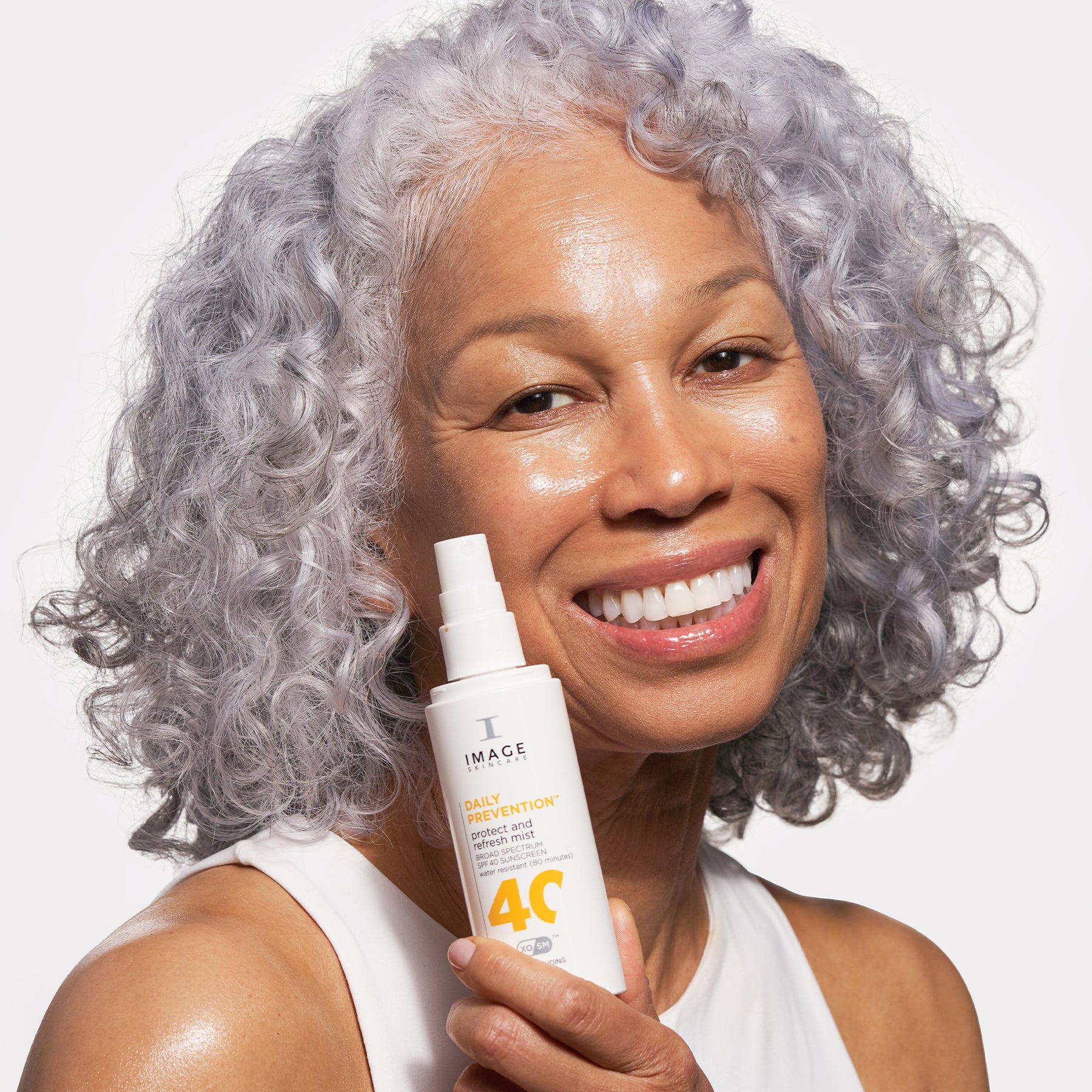 model holding product and smiling